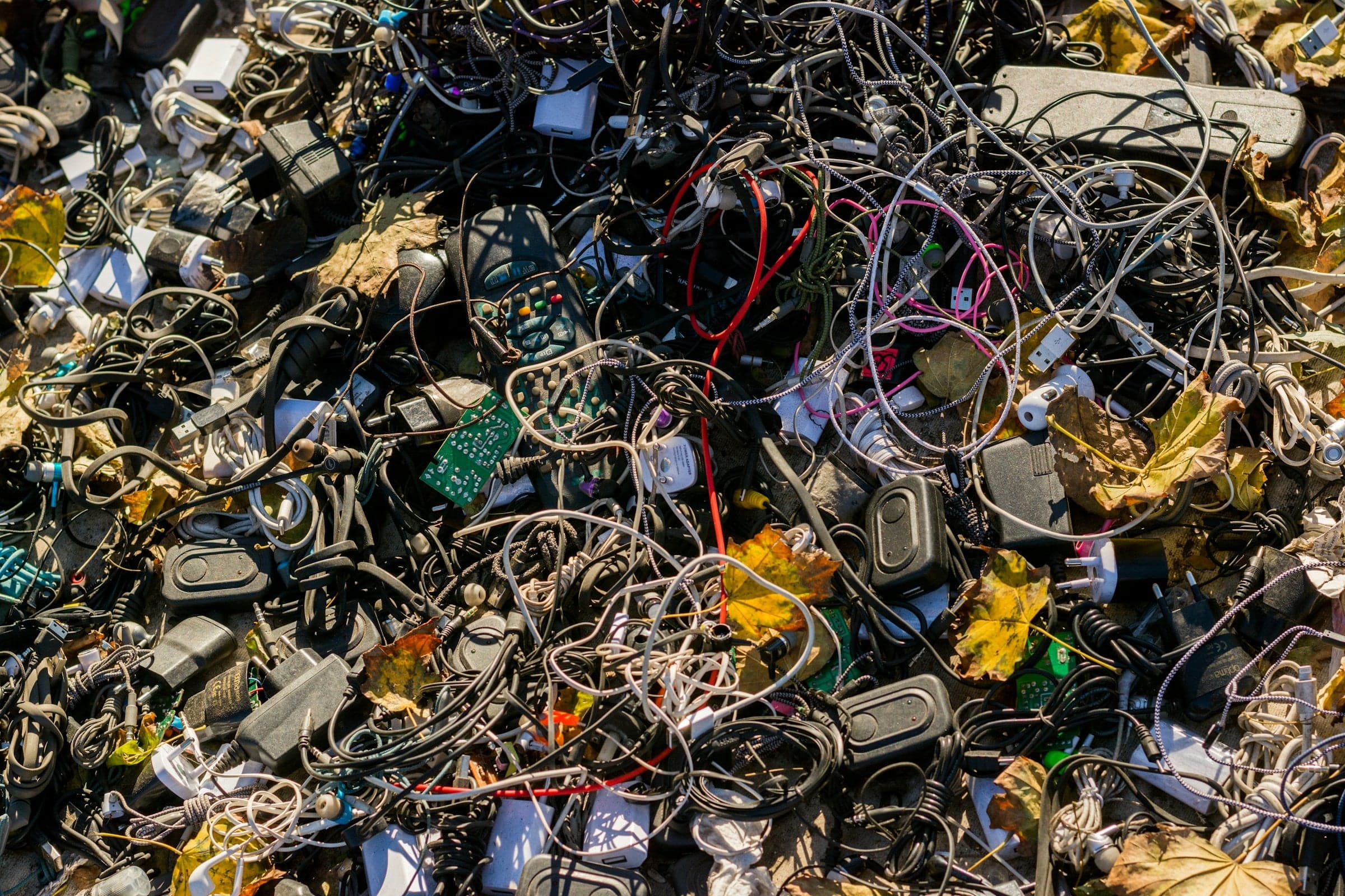 Afval van elektronische apparaten, waaronder oude smartphones, laptops en kabels, verzameld voor recycling om schadelijke stoffen te verminderen en waardevolle materialen terug te winnen.