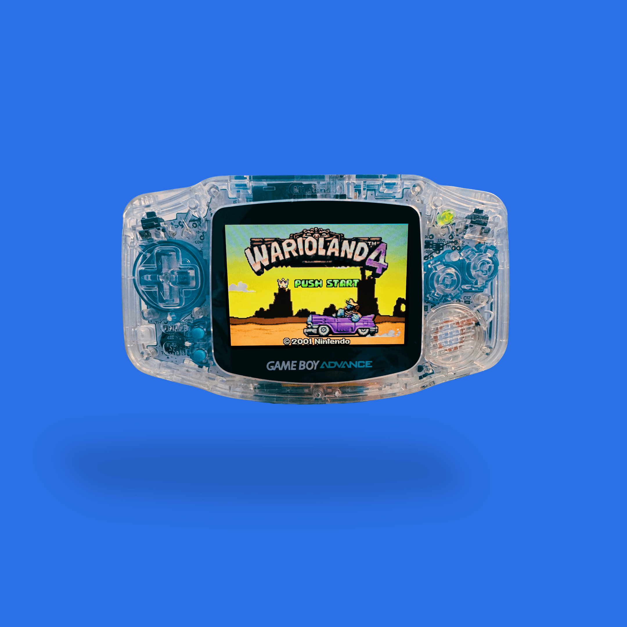 Een door RetroGear gemodde transparante Nintendo Game Boy Advance met blauwe details en het spel Wario Land 4 zichtbaar op het scherm.